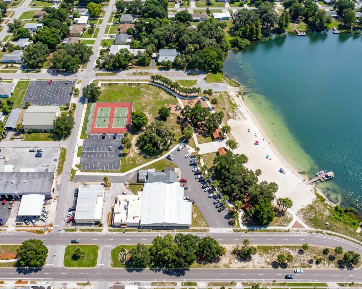 Aerial view of downtown Avon Park, Florida, showing a lakeside park, sandy beach, and tennis courts on Lake Verona.