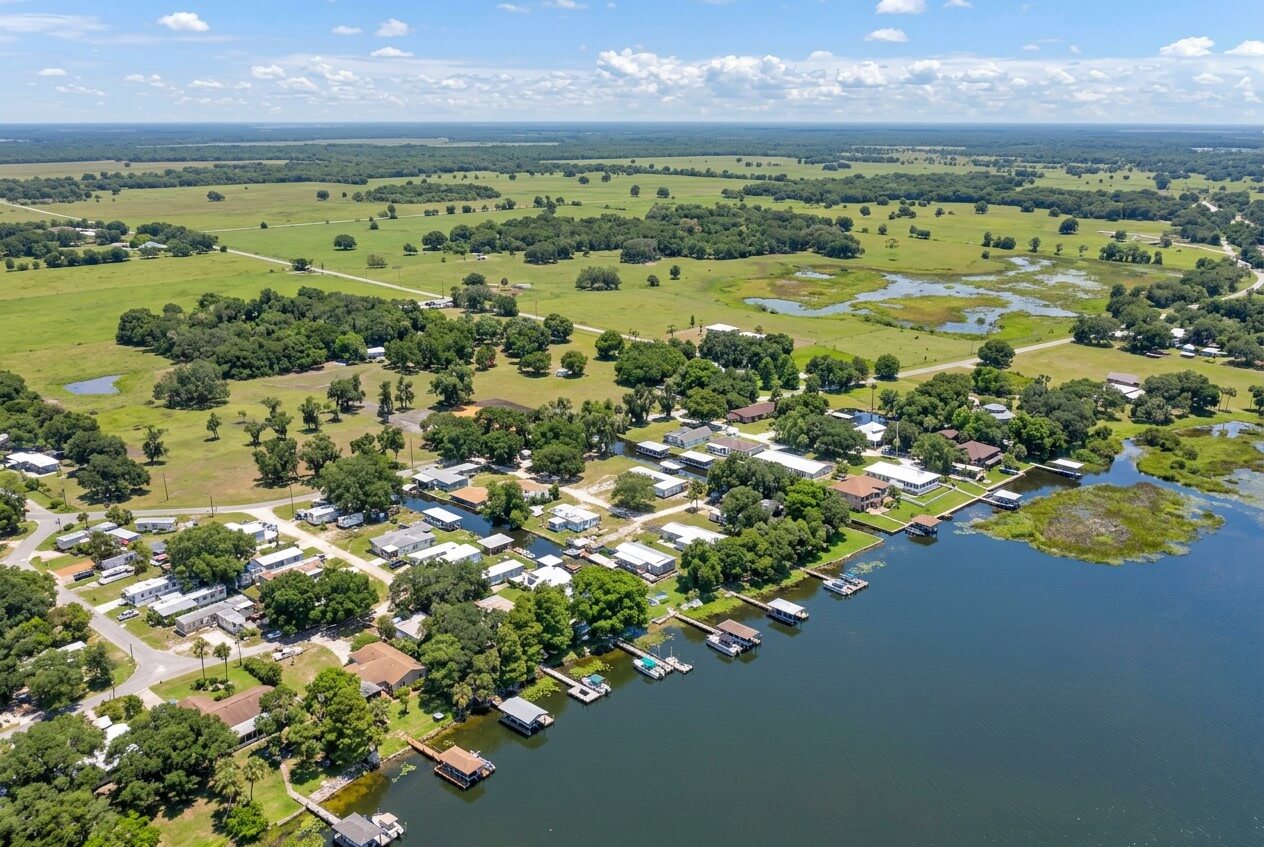 Aerial view of Lake Istokpoga in Lorida, Florida, featuring waterfront homes and lush green agricultural landscapes.